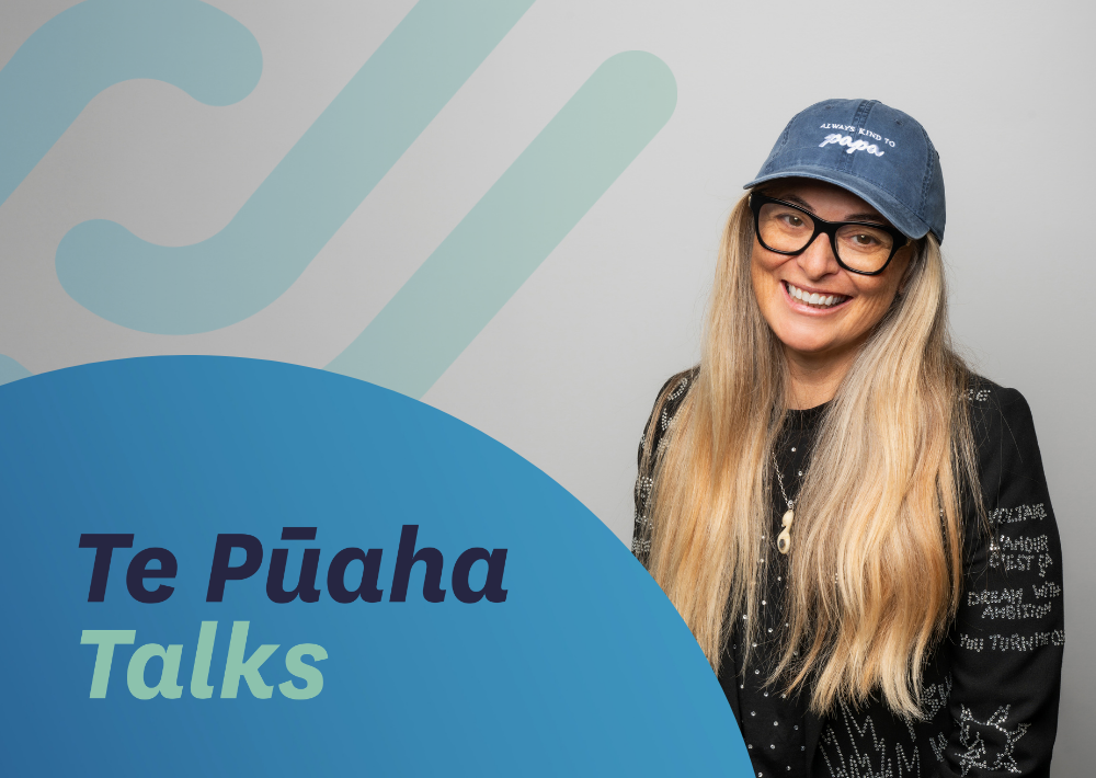 Centre for Social Impact Associate Tuihana Ohia smiles at the camera, wearing a decorated jacket and denim cap. Text reads ‘Te Pūaha Talks.’